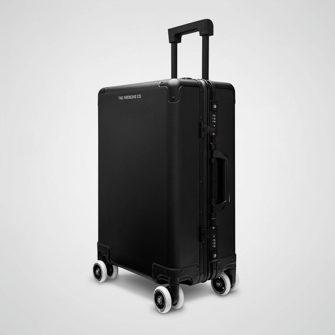 Black suitcase with wheels on a light gray background