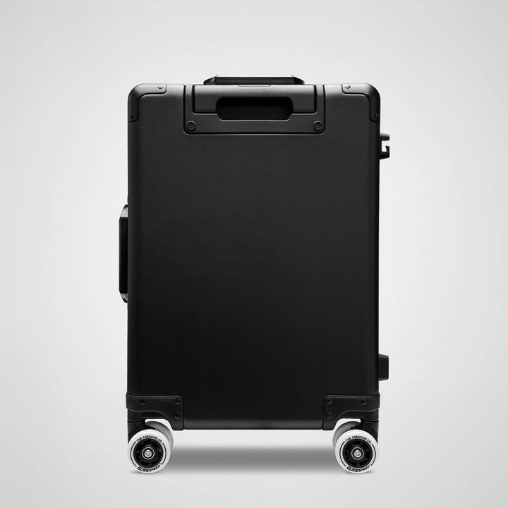 Black suitcase with wheels on a light gray background