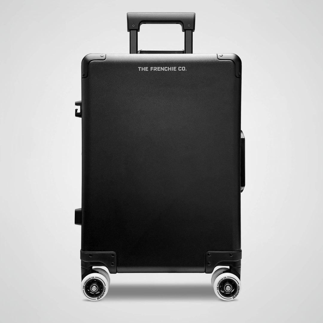 Black suitcase with 'The Frenchie Co.' branding on a light gray background