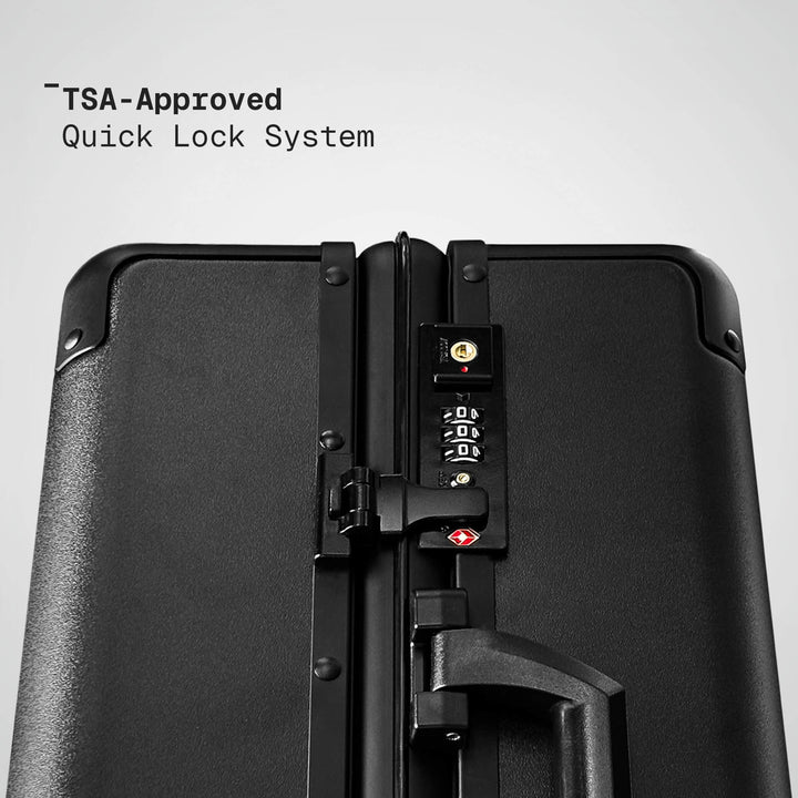 Black suitcase with TSA-approved quick lock system on a gray background