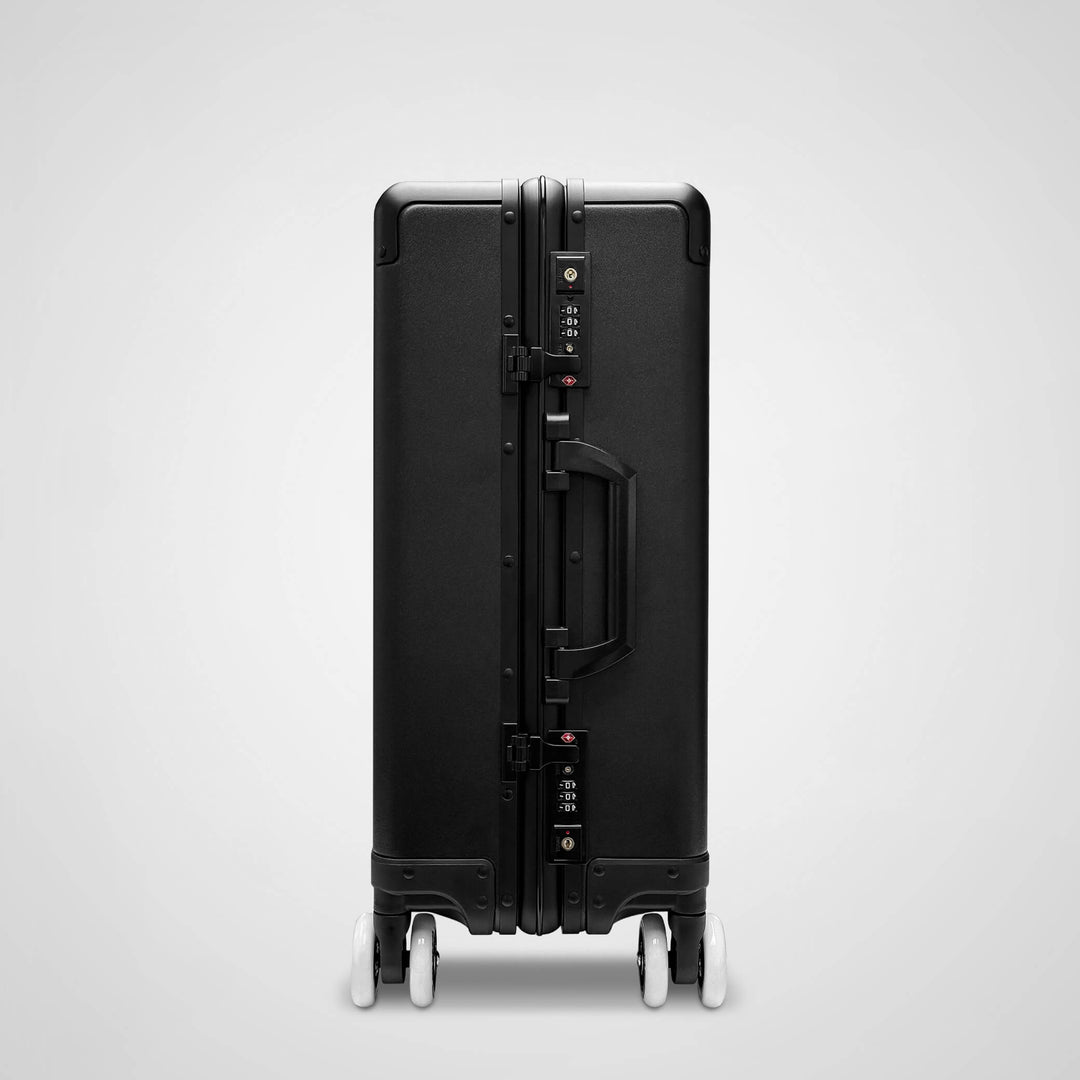 Black suitcase with wheels on a light gray background