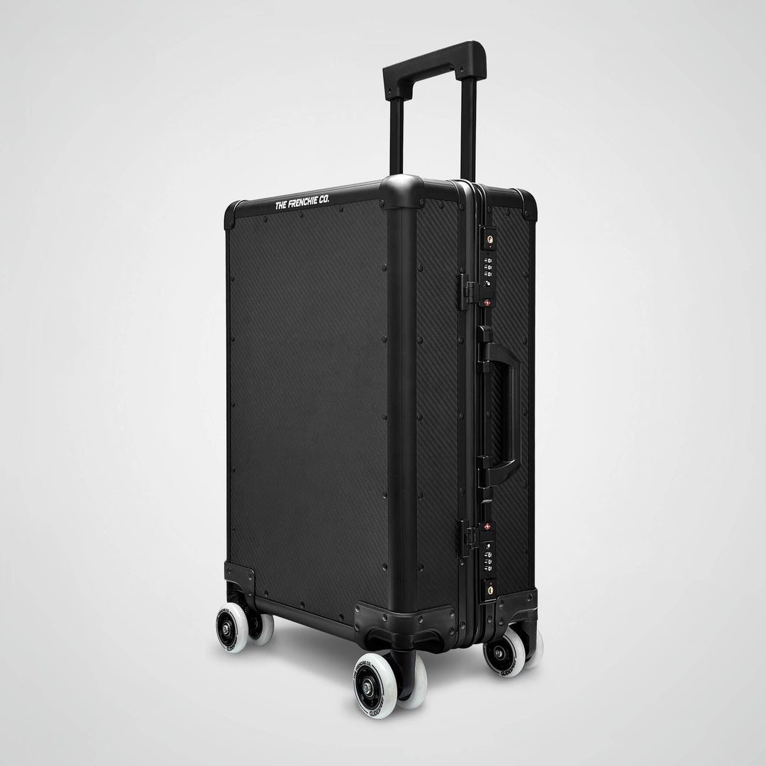 Black suitcase with wheels on a light gray background