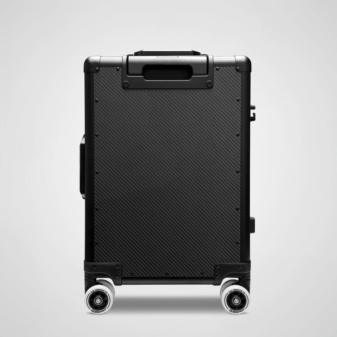 Black suitcase with wheels on a light gray background