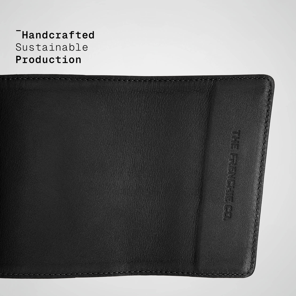 Black leather wallet with 'The Frenchie Co.' branding on a light gray background