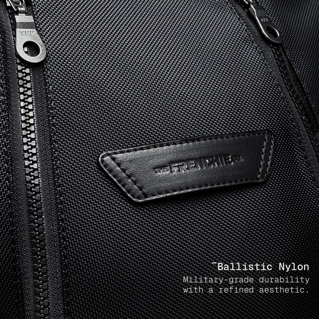 Close-up of a black bag with a brand logo and text about ballistic nylon durability.