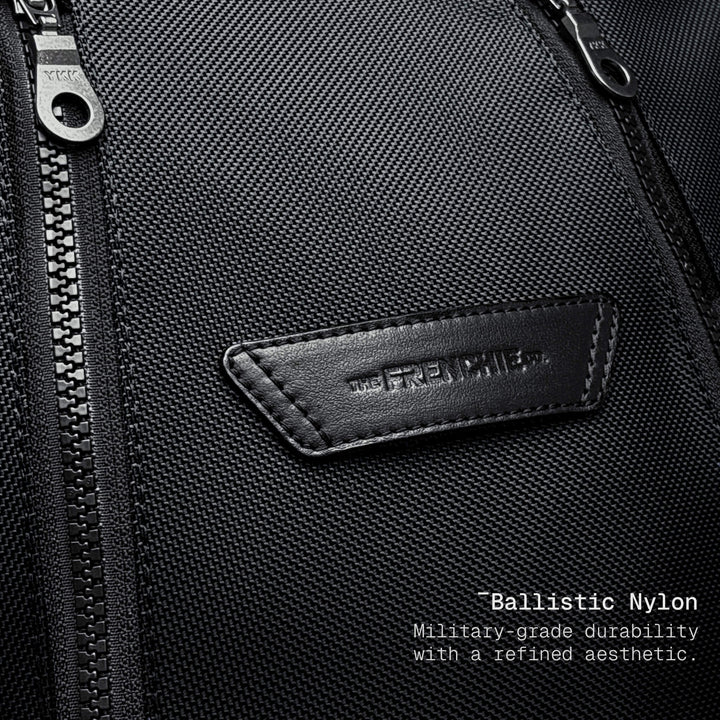 Close-up of a black bag with a brand logo and text about ballistic nylon durability.
