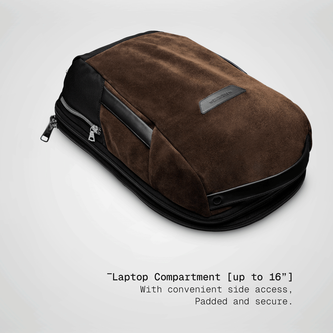 Laptop sliding into the padded compartment of the brown Vector Speed Backpack