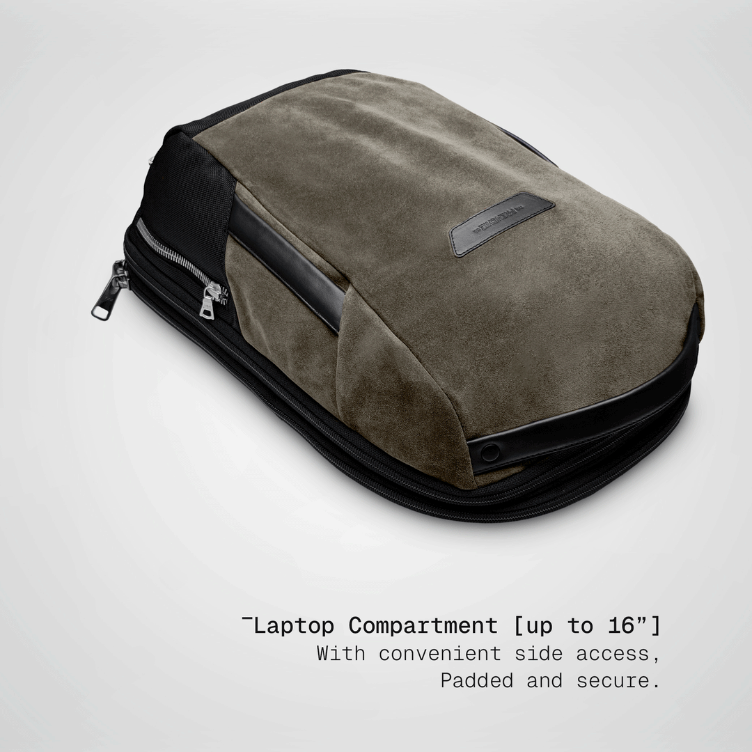 Laptop sliding into the padded compartment of the taupe Vector Speed Backpack