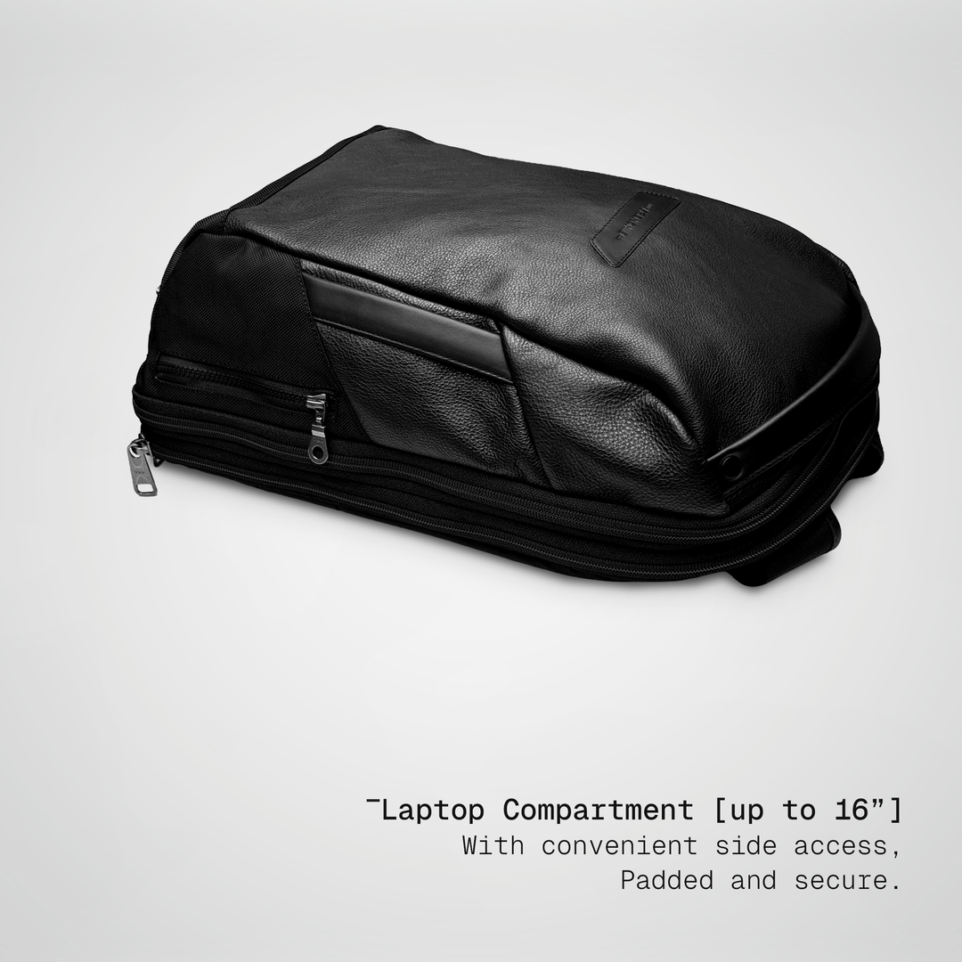 Laptop sliding into the padded compartment of the black leather Vector Speed Backpack