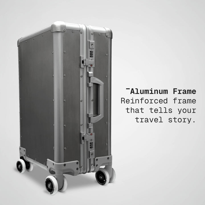 Silver suitcase with 'Aluminum Frame' text on a light gray background
