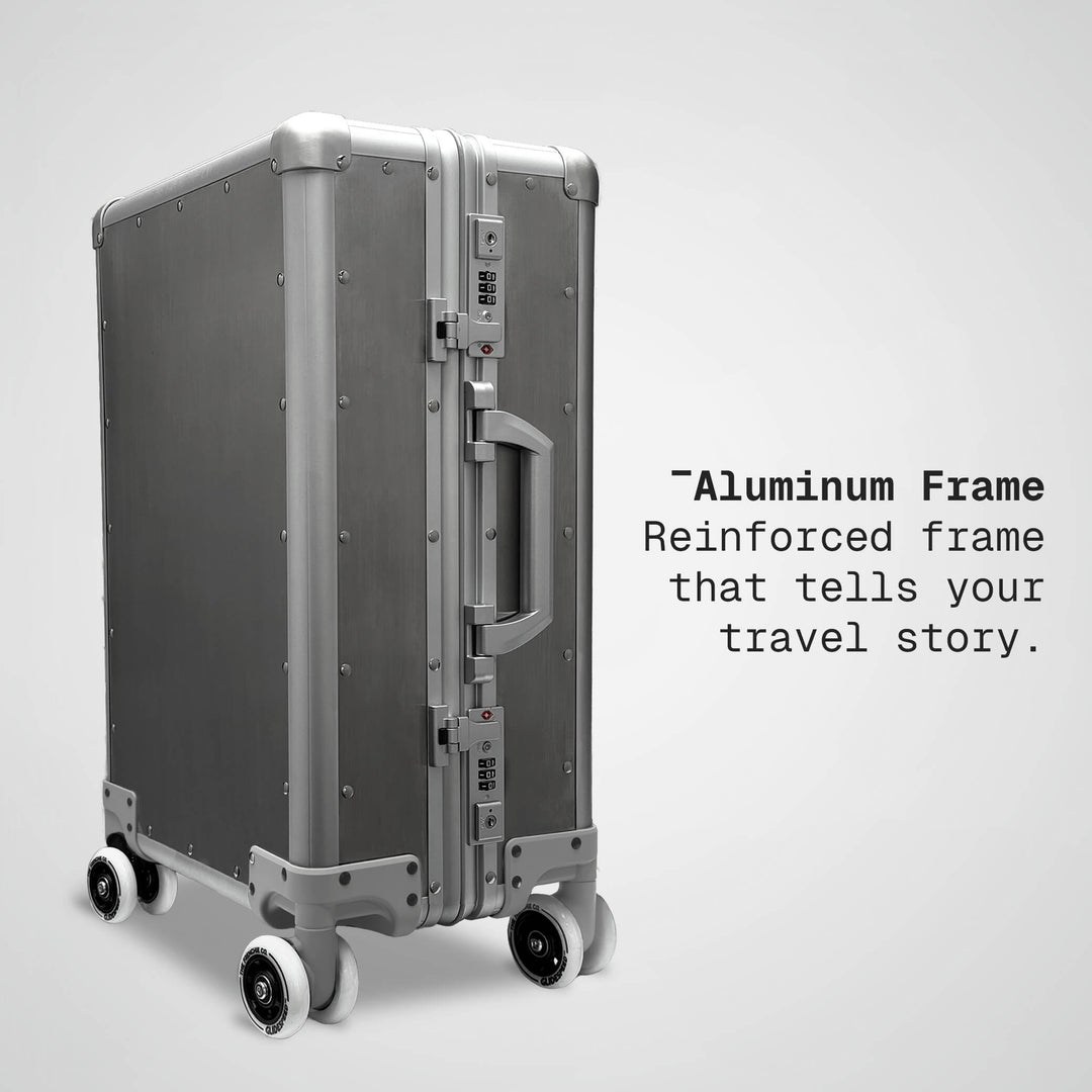 Silver suitcase with 'Aluminum Frame' text on a light gray background