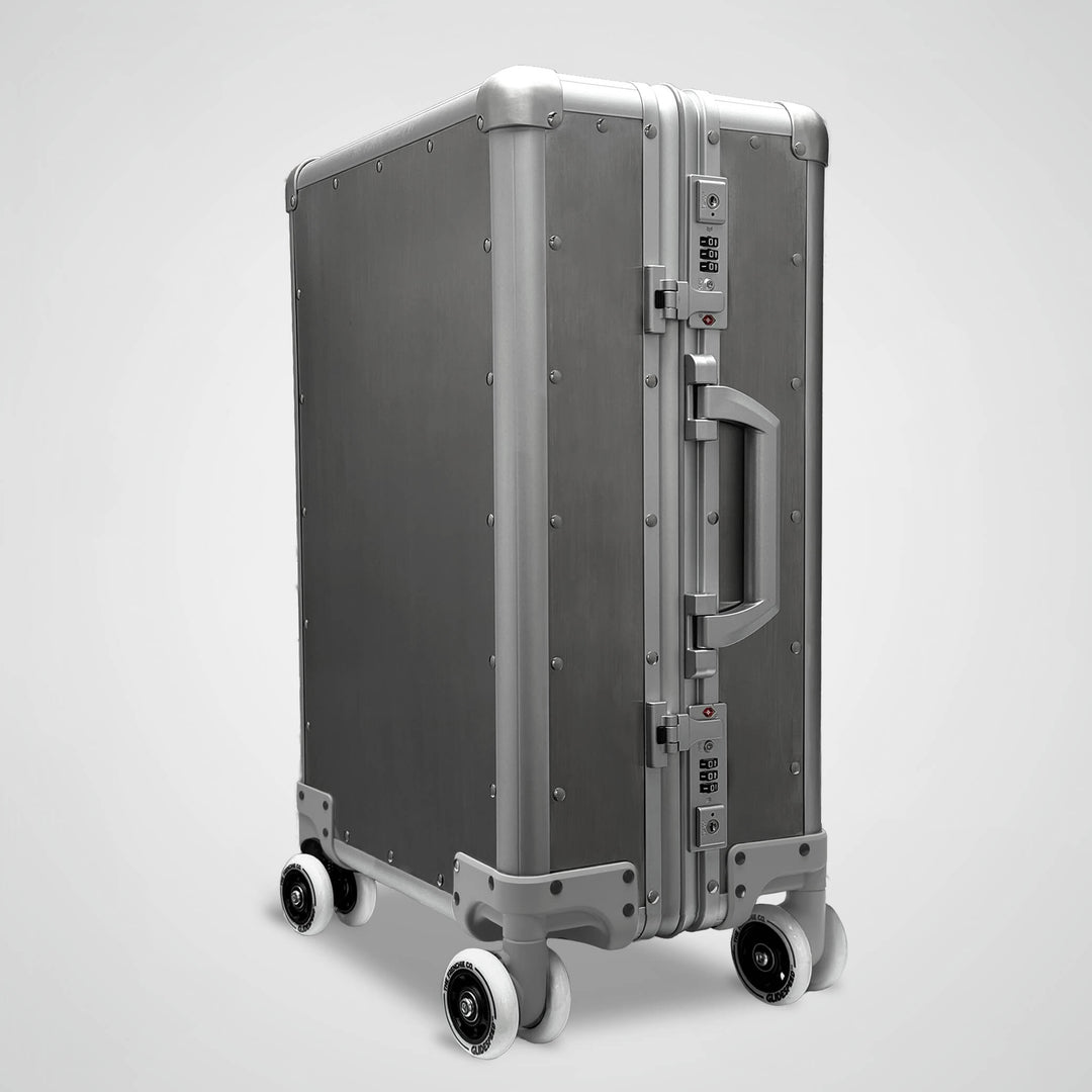 Silver suitcase with wheels on a light gray background