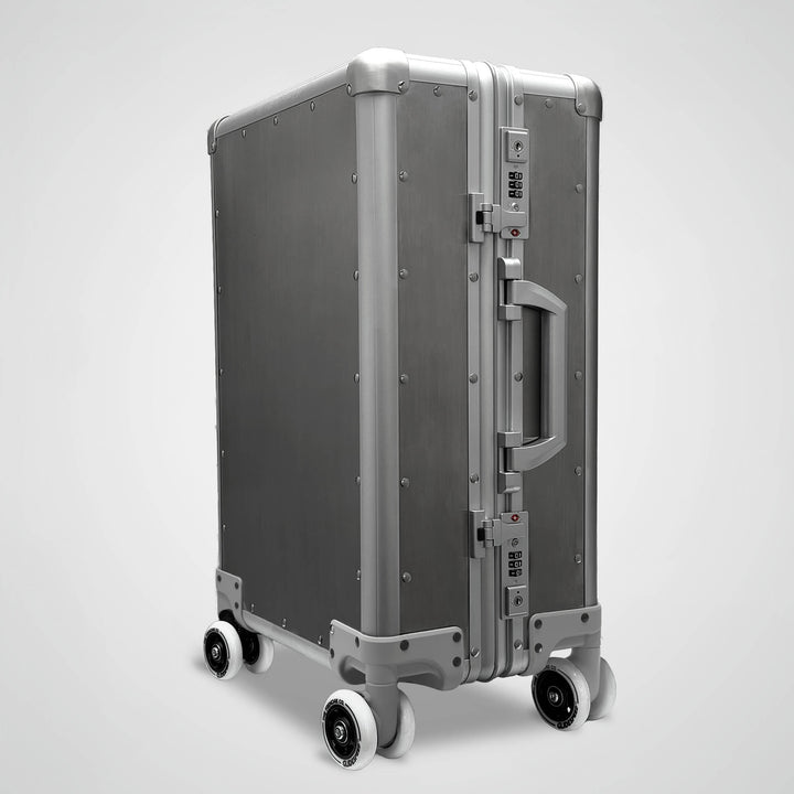 Silver suitcase with wheels on a light gray background