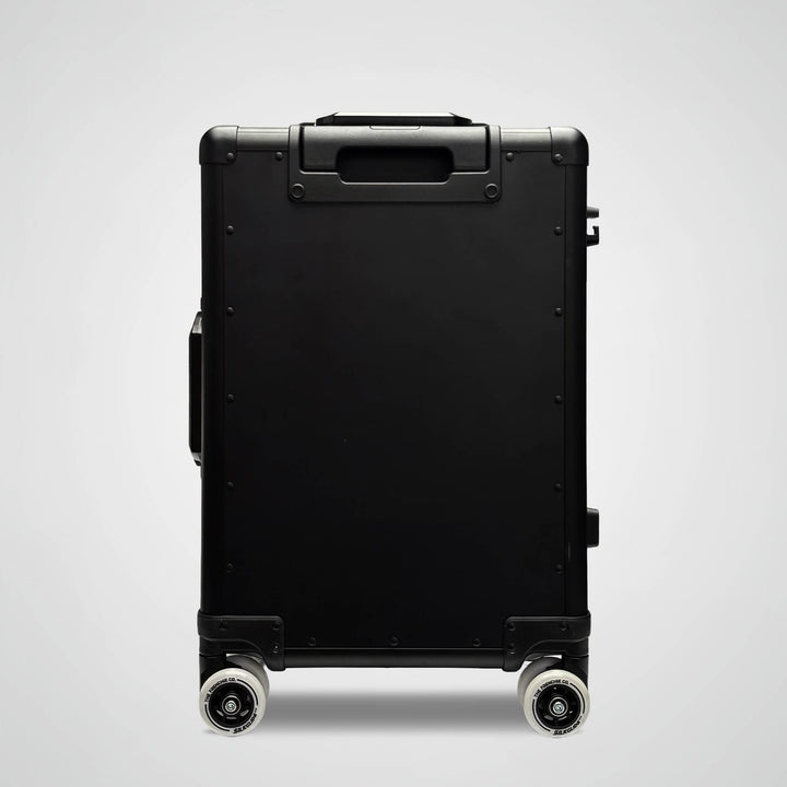 Black suitcase with wheels on a light gray background