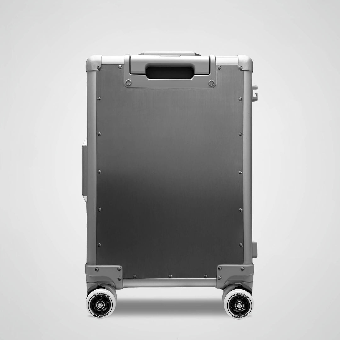Silver suitcase with wheels on a light gray background