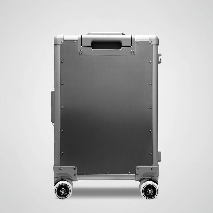 Silver suitcase with wheels on a light gray background