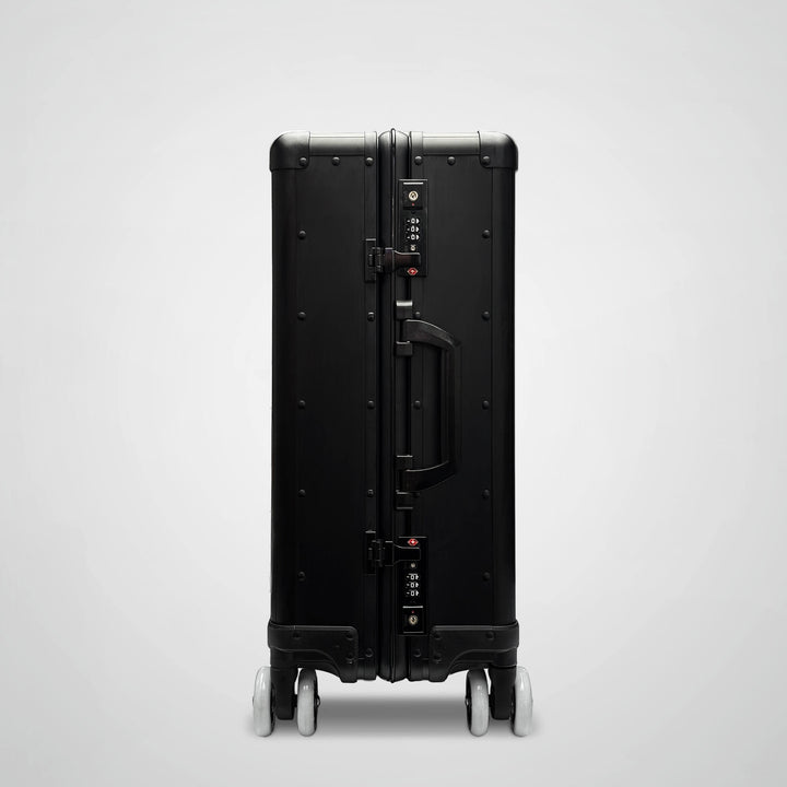 Black suitcase with wheels on a light gray background